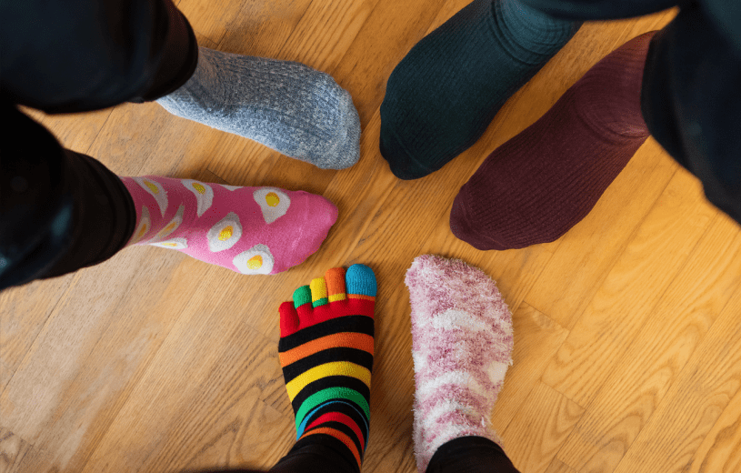 Photo of three sets of feet wearing odd socks