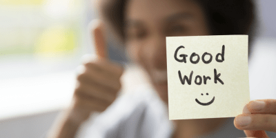 Post-It note with "Good Work" and a smiley face drawn on it